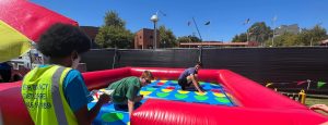 A group of happy students playing a giant inflatable game of Twister at Curtin University in Bentley.