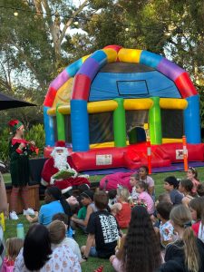 Kids and adults having fun inside a large, colorful inflatable mega dome bouncy castle.