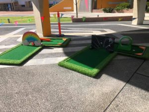 Students playing a game of mini golf on an outdoor course at ECU Joondalup.