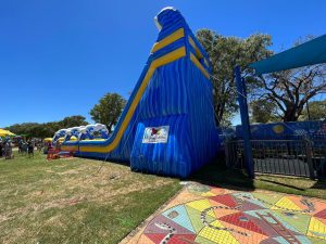 Children and families queueing to ride the 'Mega Drop' inflatable slide at an event in Mandurah.